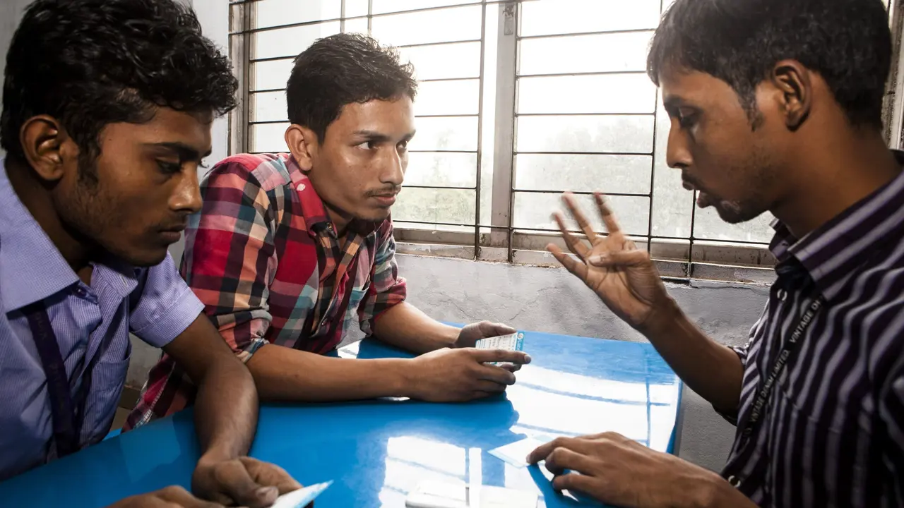 Three men having a serious discussion around a table
