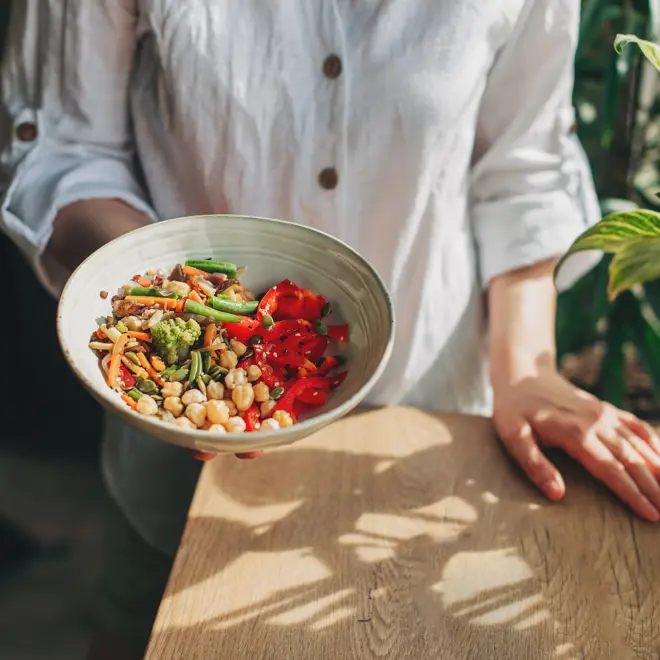 person holding a bowl of healthy food