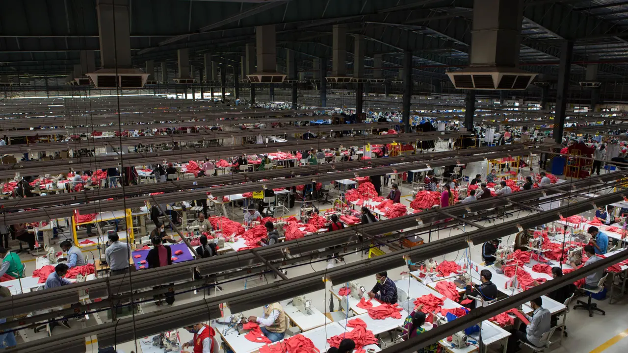 An aerial view of a textile factory and many workers at individual work stations