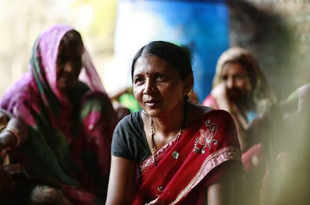 A woman wearing a red saari looking at the camera