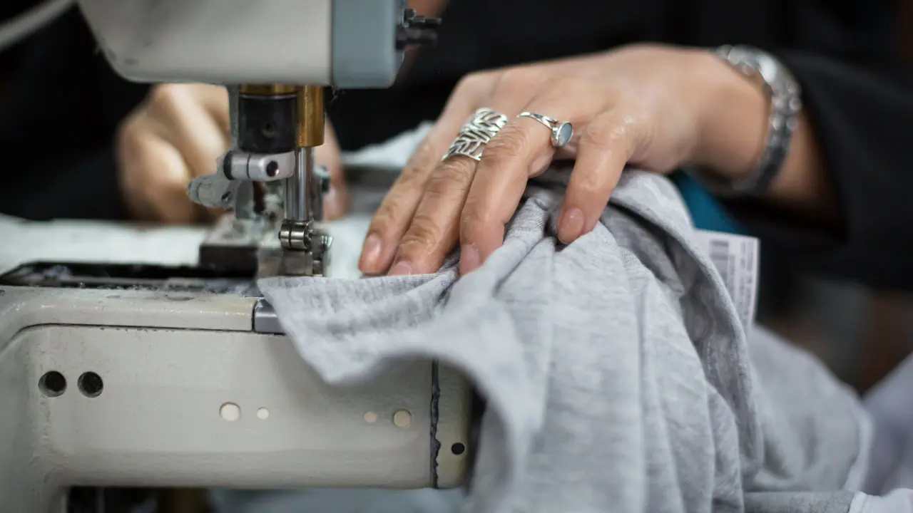 A close up of hands using a sewing machine
