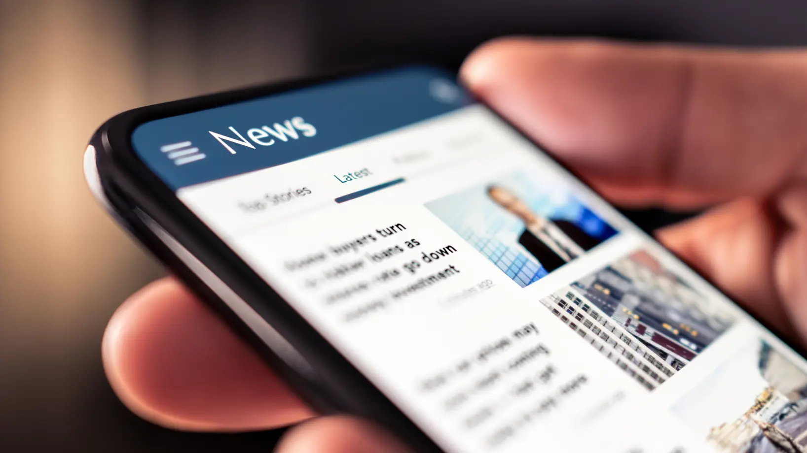 A closeup of a hand holding a mobile device with a news app open on the screen