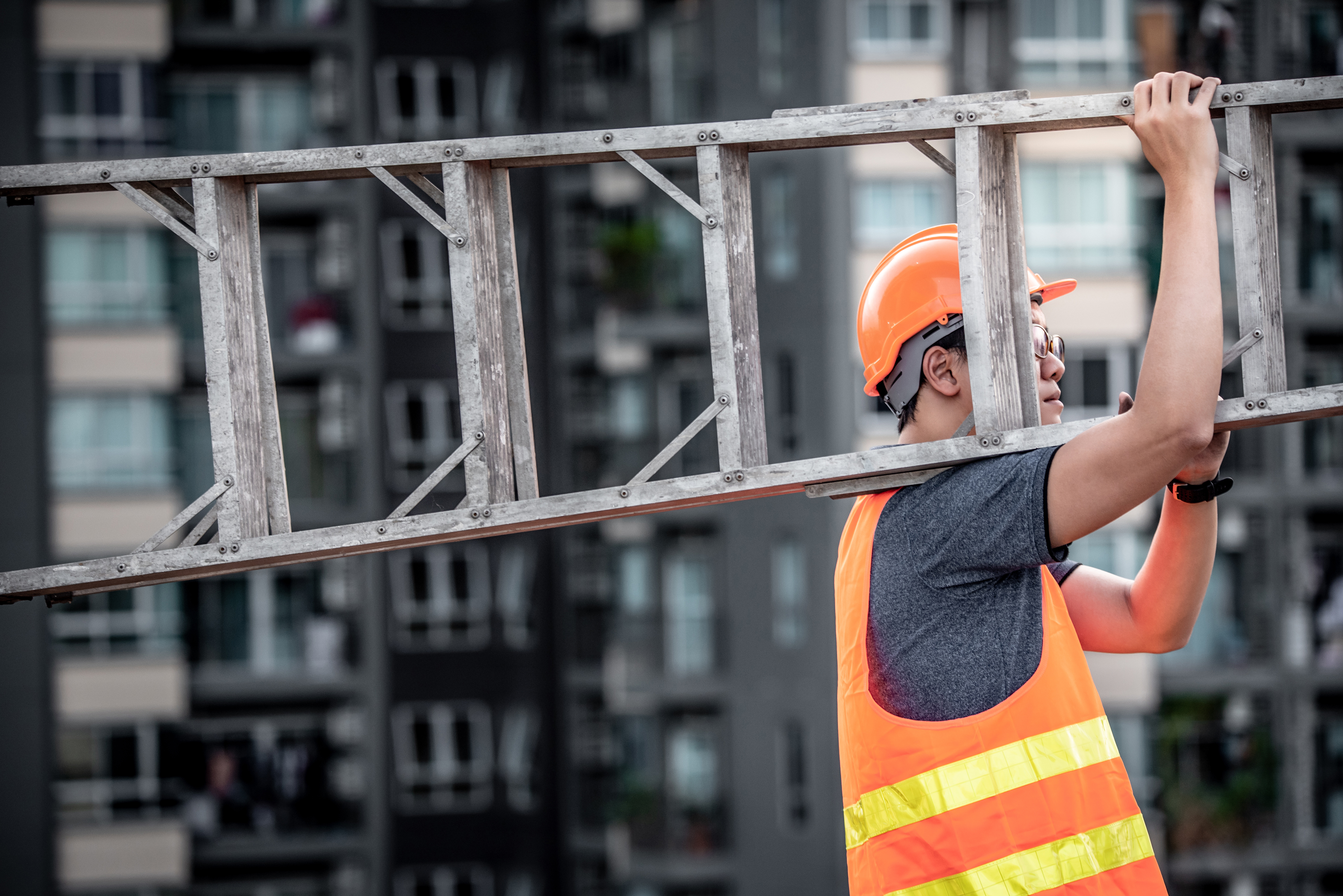 builder holding a wooden ladder